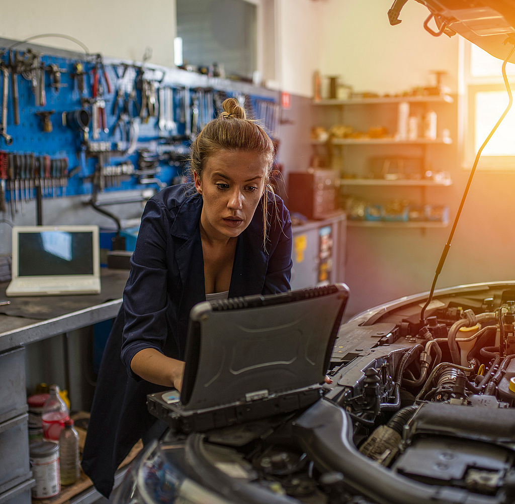 Woman working on a laptop in a garage
