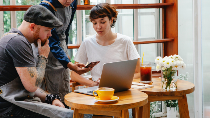 Three people at a table making a payment